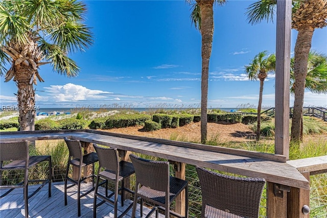 wooden deck with a water view and an outdoor bar