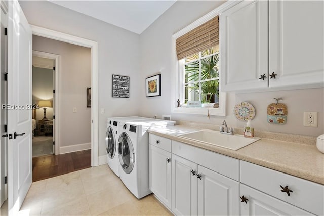 laundry area featuring cabinets, light tile patterned flooring, sink, and independent washer and dryer