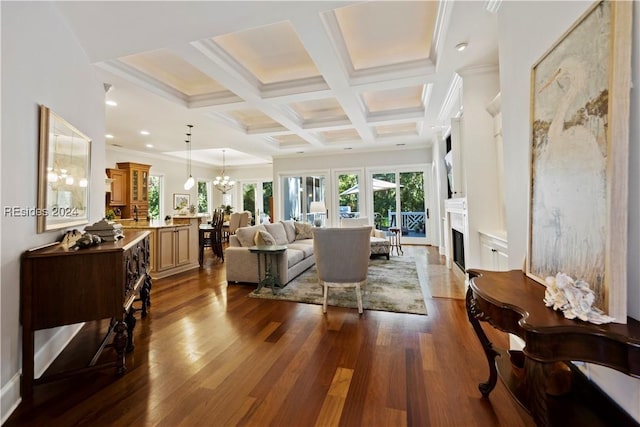 living room with beam ceiling, coffered ceiling, ornamental molding, dark hardwood / wood-style flooring, and a chandelier