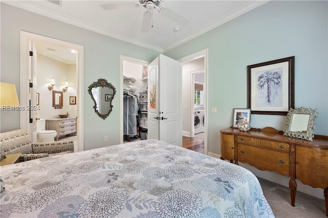 carpeted bedroom with crown molding, a walk in closet, washer and dryer, a closet, and ceiling fan