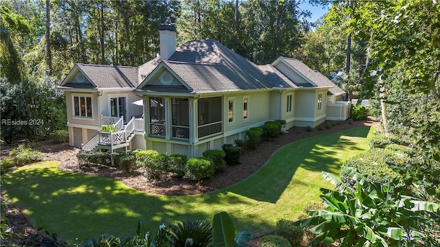 rear view of property with a sunroom and a yard