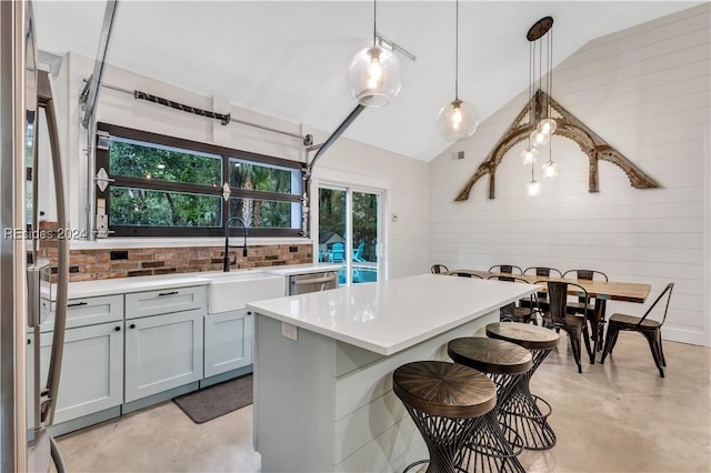 kitchen featuring pendant lighting, sink, a breakfast bar, appliances with stainless steel finishes, and a center island