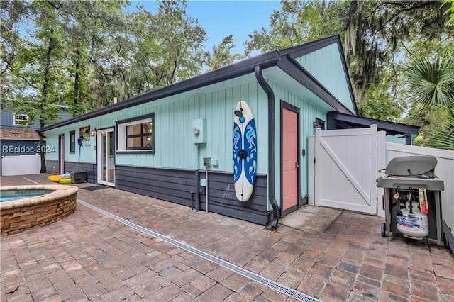 exterior space featuring an in ground hot tub and a patio