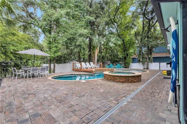 view of swimming pool featuring an in ground hot tub and a patio