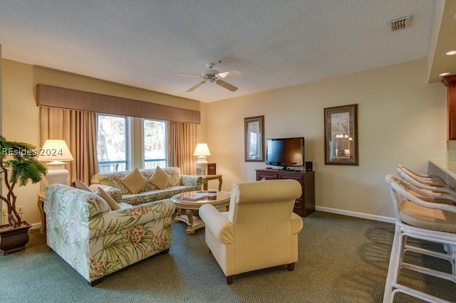 carpeted living room featuring ceiling fan and a textured ceiling