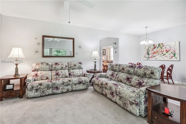 living room featuring ceiling fan with notable chandelier and carpet floors