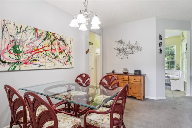 carpeted dining room featuring an inviting chandelier and a textured ceiling