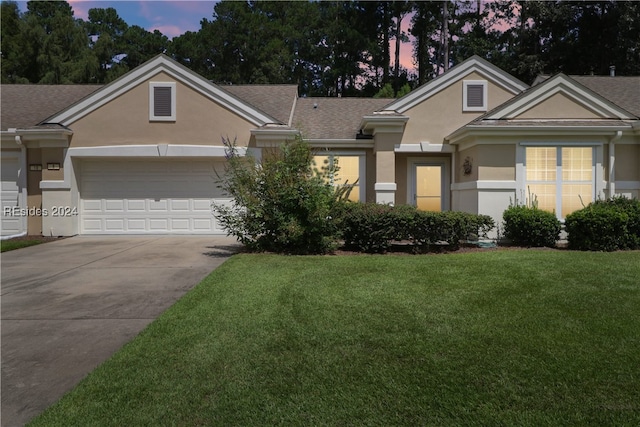 view of front of house featuring a garage and a yard