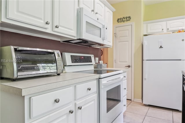 kitchen featuring white cabinetry, light tile patterned floors, and white appliances