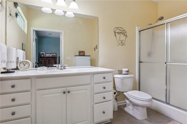 bathroom featuring tile patterned flooring, vanity, a shower with door, and toilet