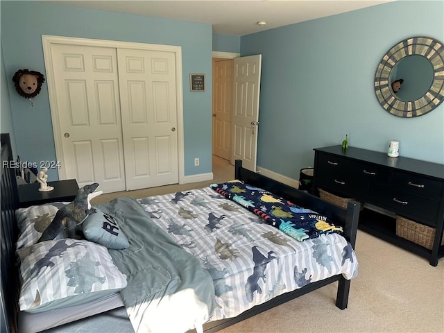 bedroom featuring light colored carpet and a closet