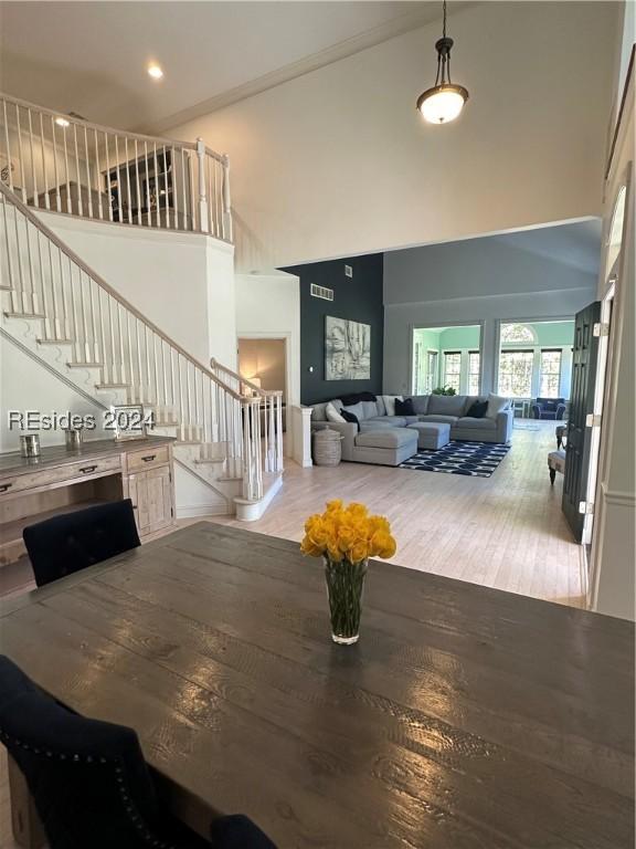 dining area featuring a high ceiling and hardwood / wood-style flooring