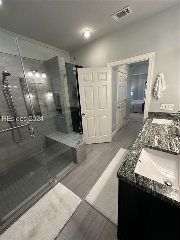 bathroom featuring vanity and a shower with shower door