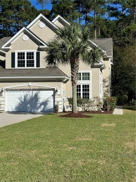 view of front of home with a garage and a front lawn