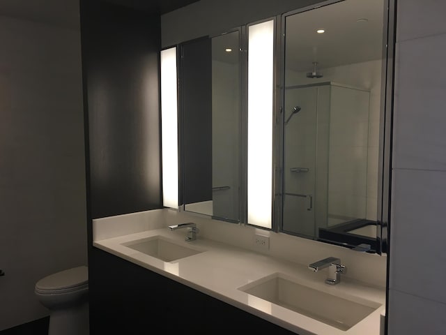 bathroom with dual bowl vanity and toilet