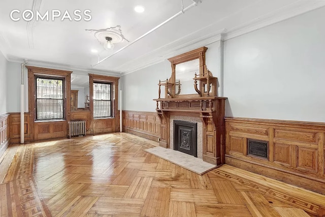 unfurnished living room featuring crown molding, radiator heating unit, and light parquet floors