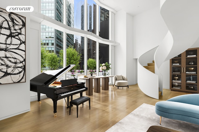 misc room with light wood-type flooring, a wealth of natural light, and a high ceiling