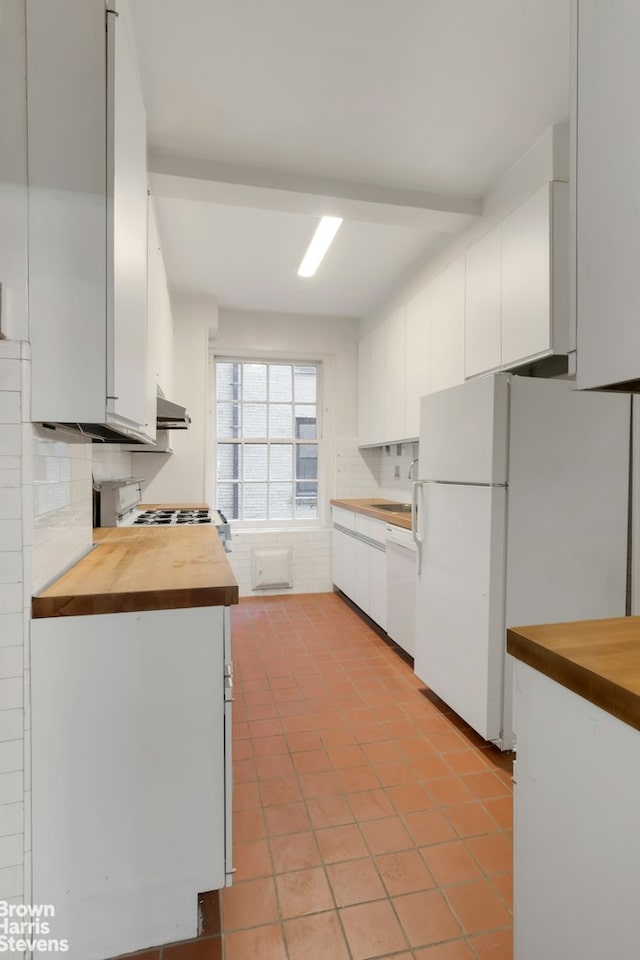 kitchen with white appliances, white cabinetry, tasteful backsplash, and butcher block countertops