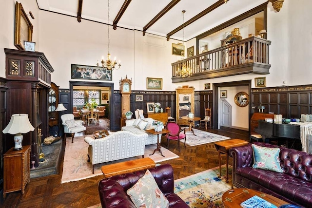 living room with a notable chandelier, dark parquet floors, a high ceiling, and beamed ceiling