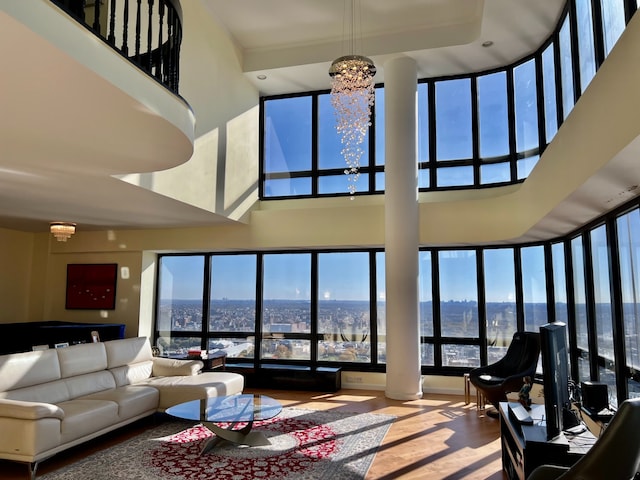 living room with a towering ceiling, wood-type flooring, and a chandelier