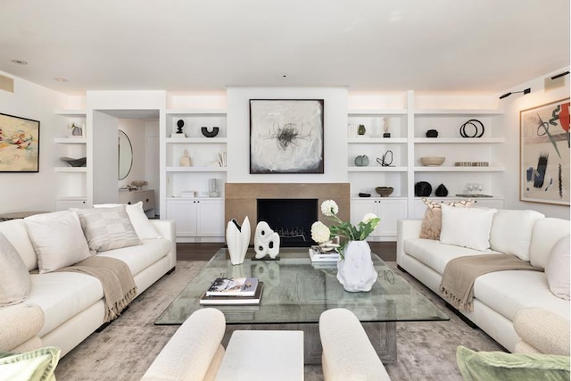 living room featuring light hardwood / wood-style flooring and built in shelves