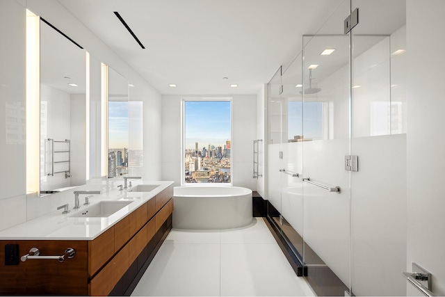 bathroom featuring independent shower and bath, dual vanity, and tile floors