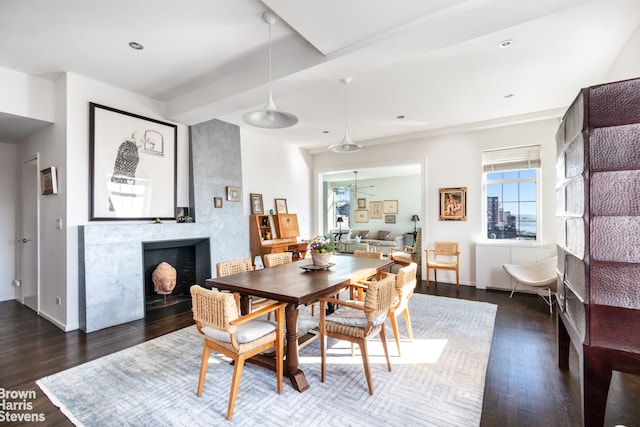 dining room with dark hardwood / wood-style flooring and a large fireplace