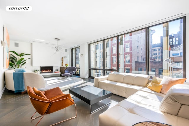 living room with a wealth of natural light, parquet flooring, and a wall of windows