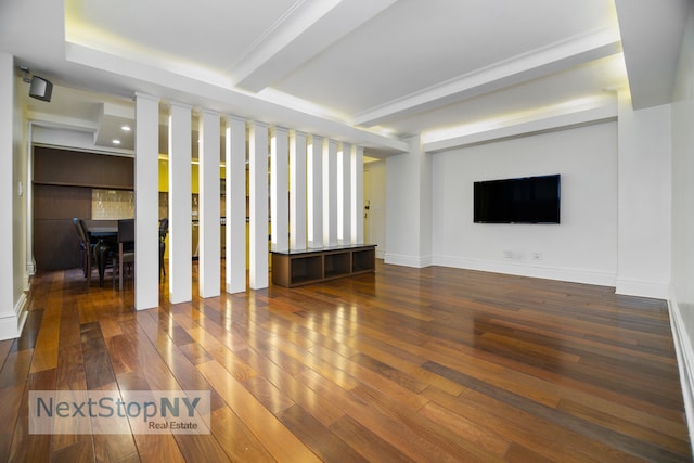 unfurnished living room with beam ceiling and dark hardwood / wood-style floors