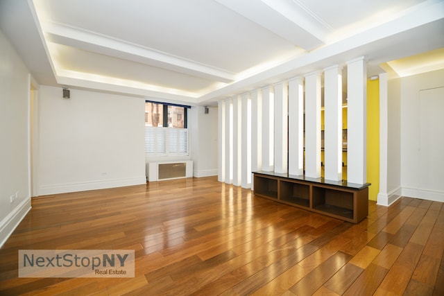 interior space featuring hardwood / wood-style flooring, beamed ceiling, and radiator