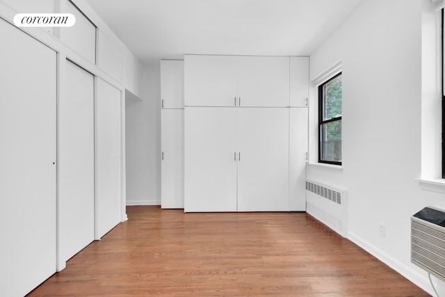 unfurnished bedroom with radiator and light hardwood / wood-style flooring