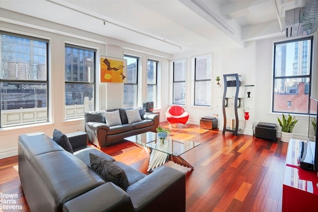 living room featuring a wealth of natural light, beam ceiling, and hardwood / wood-style floors