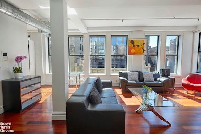 interior space with plenty of natural light, beam ceiling, and dark hardwood / wood-style flooring