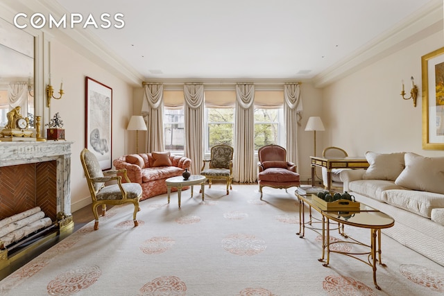 living room featuring ornamental molding, a fireplace, and light hardwood / wood-style flooring