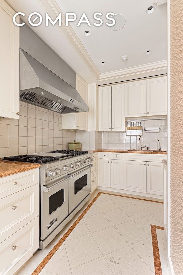 kitchen featuring wall chimney exhaust hood, double oven range, tasteful backsplash, and light tile floors