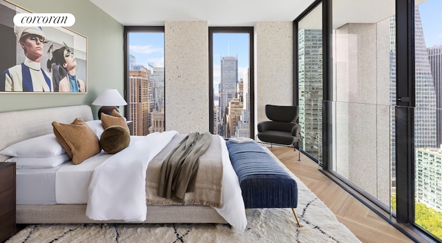 bedroom featuring a wall of windows, multiple windows, and light wood-type flooring