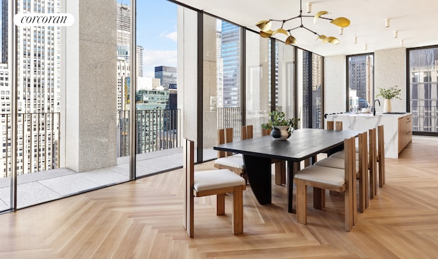 dining area featuring a notable chandelier and light parquet flooring