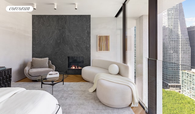 bedroom featuring multiple windows, a premium fireplace, and wood-type flooring