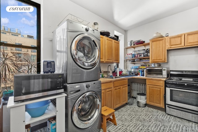 washroom with stacked washer and dryer, radiator, and sink