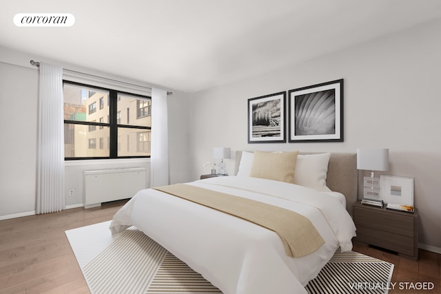 bedroom with wood-type flooring and radiator heating unit