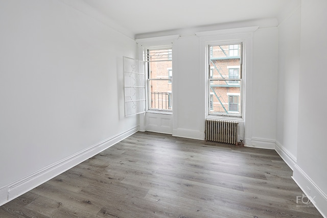 spare room with radiator and dark wood-type flooring