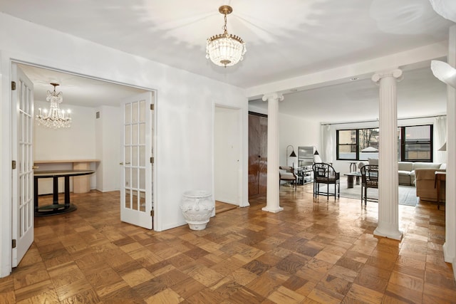 interior space with parquet floors, an inviting chandelier, and ornate columns