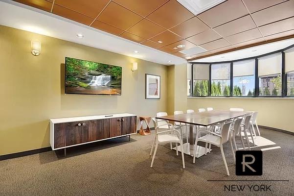 carpeted dining area with a paneled ceiling