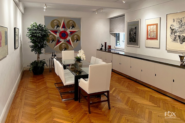 dining room featuring beamed ceiling and light parquet floors