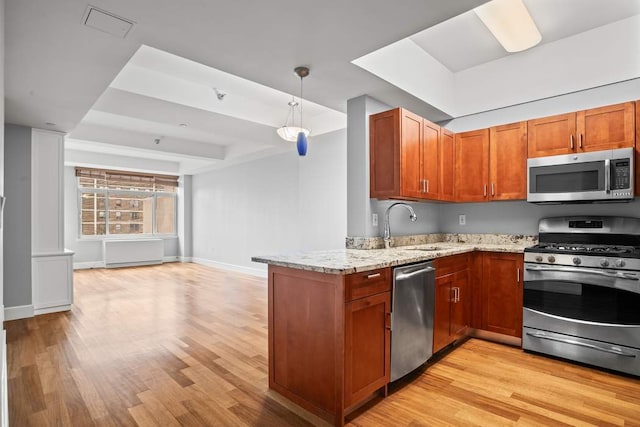 kitchen featuring decorative light fixtures, kitchen peninsula, stainless steel appliances, light stone counters, and light hardwood / wood-style floors