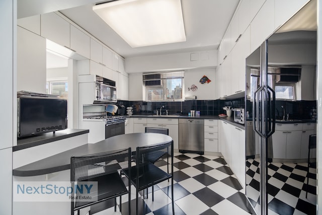 kitchen featuring white cabinetry, stainless steel appliances, and plenty of natural light