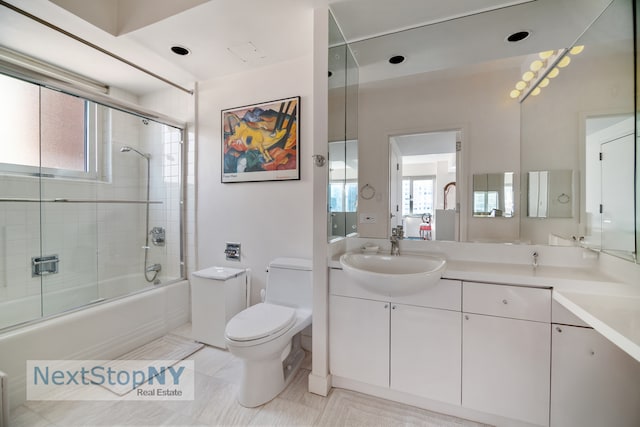 full bathroom featuring toilet, enclosed tub / shower combo, vanity, and tile patterned floors