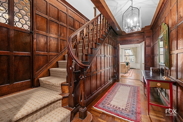 foyer featuring wood walls and a notable chandelier