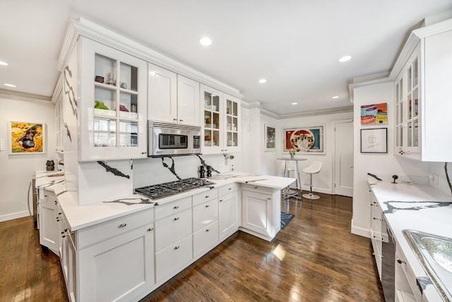 kitchen featuring white cabinets, ornamental molding, sink, stainless steel appliances, and dark hardwood / wood-style flooring