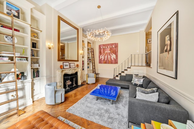 living room featuring parquet floors, built in shelves, beam ceiling, and a chandelier